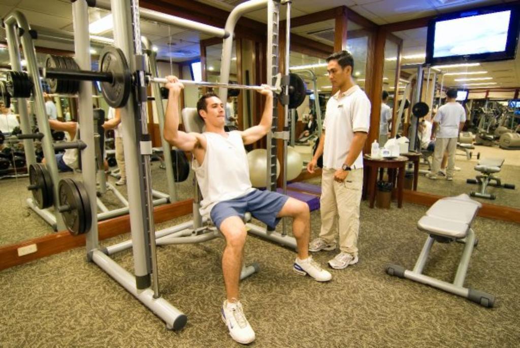 Hotel Marco Polo Davao City Exteriér fotografie A personal trainer assisting a client with a weight training exercise